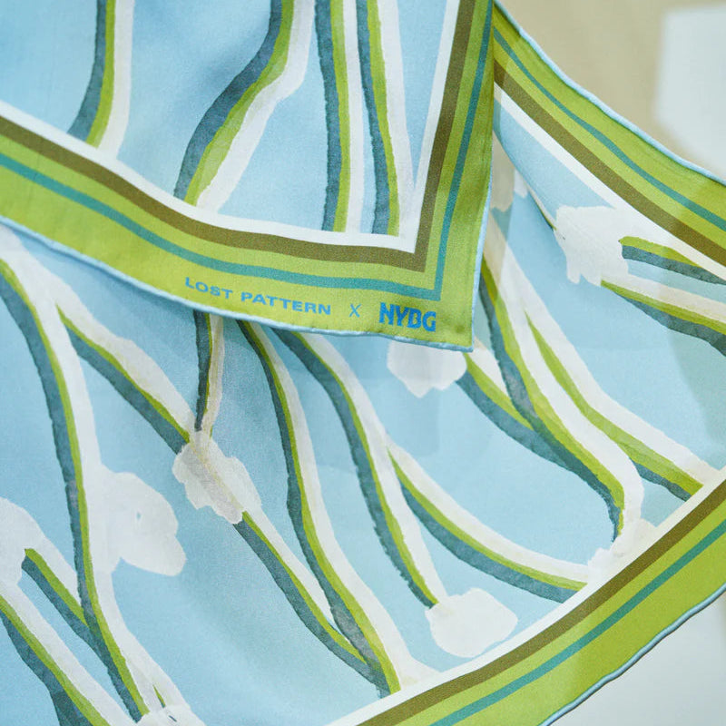 Close-up of a patterned fabric with green and blue design on a white background